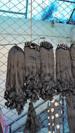 Photo for Bangalore,Karnataka,India-January 01 2023: Womens black hair wig is on sale in the streets of Shivaji nagar, Opposite to Busstand, Bangalore. - Royalty Free Image