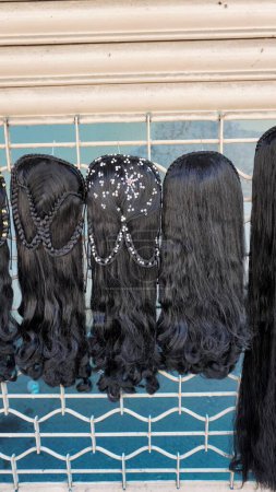 Photo for Bangalore,Karnataka,India-January 01 2023: Womens black hair wig is on sale in the streets of Shivaji nagar, Opposite to Busstand, Bangalore. - Royalty Free Image