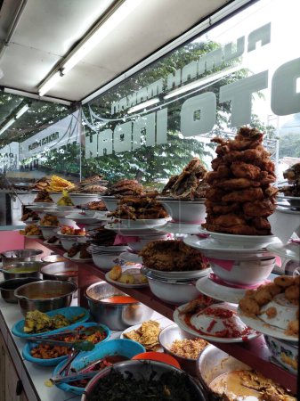 Foto de Masakan Padang menu of restaurant. Popular dishes from a Padang eatery, served on layers of plate stacks. - Imagen libre de derechos