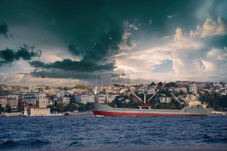 Photo for The view of the Maiden's Tower and the cargo ship passing through the Bosphorus. - Royalty Free Image