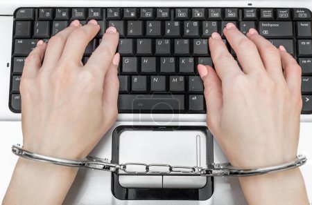Foto de Las manos en las esposas están escribiendo en el teclado de la computadora portátil. - Imagen libre de derechos