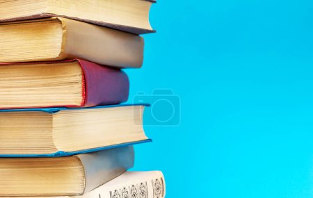 Photo for Stack of different books on blue background. Copy space for text. - Royalty Free Image