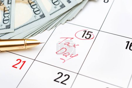 Photo for Tax day written on calendar and money. Close up. - Royalty Free Image