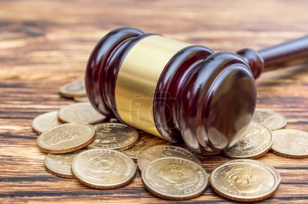 Photo for Judge's gavel with coins on the table. Close up. - Royalty Free Image