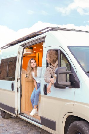 A young couple is seen cherishing a moment together inside their modern luxury campervan, symbolizing adventure and a carefree lifestyle.