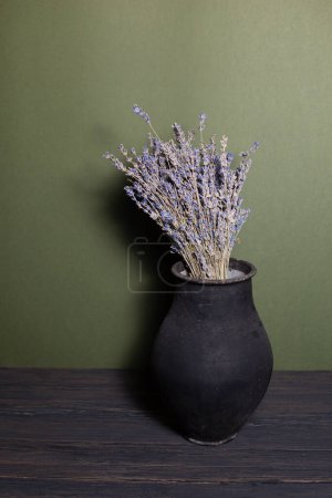 Photo for Black jug with lavender flowers on a beautiful background - Royalty Free Image
