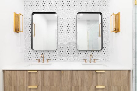 Téléchargez les photos : Une belle salle de bain avec une armoire à vanité en bois flottant, robinet en or et lumières, mur de carreaux de mosaïque, et des miroirs rectangulaires. - en image libre de droit