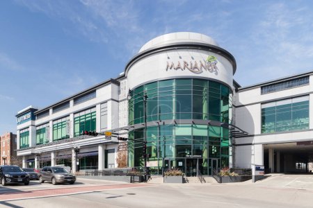 Foto de Chicago, IL, USA - April 28, 2023: The exterior of a modern exterior, Mariano's grocery store, owned by Kroger, with an entrance to a covered garage and an LA Fitness in the distance. - Imagen libre de derechos