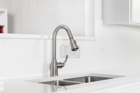 Photo for A kitchen sink detail with a chrome faucet, subway tile backsplash, and a chrome faucet. - Royalty Free Image