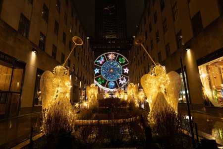 Téléchargez les photos : New York, NY, USA - 11 décembre 2023 : Regard du Rockefeller Center vers le Carrousel des rêves de Christian Dior et de la Cinquième Avenue de Sak la nuit. - en image libre de droit