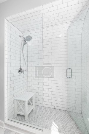 Téléchargez les photos : Une douche à l'italienne avec murs en tuiles de métro, sol en carreaux de marbre hexagonal et un robinet chromé. - en image libre de droit