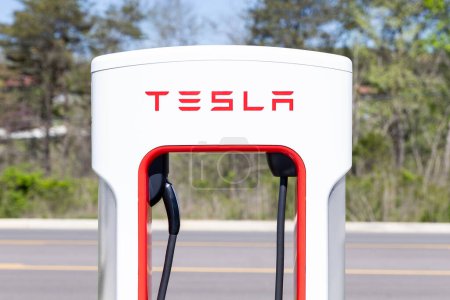 Téléchargez les photos : Sevierville, TN, USA - April 13, 2024: Closeup of a white and red Tesla charging station in a parking lot with no vehicles. - en image libre de droit