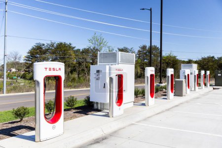 Téléchargez les photos : Sevierville, TN, USA - 13 avril 2024 : Une rangée de bornes de recharge Tesla blanches et rouges dans un parking sans véhicules. - en image libre de droit