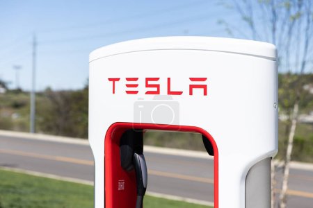 Téléchargez les photos : Sevierville, TN, USA - 13 avril 2024 : Gros plan d'une borne de recharge Tesla blanche et rouge dans un parking sans véhicule. - en image libre de droit