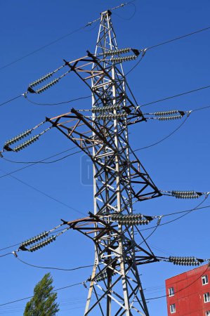 Photo for A transmission tower on the background of a red residential building - Royalty Free Image