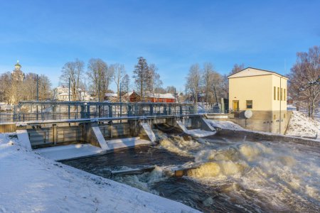Wasserspülung aus einem offenen Tor in einem Wasserkraftwerk in Schweden, im Winter mit Schnee und Sonnenlicht