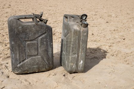 Old jerrycans on desert sand