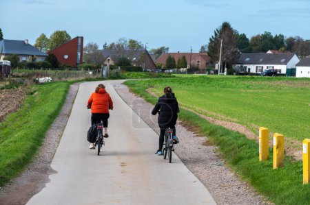Téléchargez les photos : Asse, Brabant flamand, Belgique - 10 20 2022 - Couple conduisant le vélo à travers les champs de la campagne flamande - en image libre de droit
