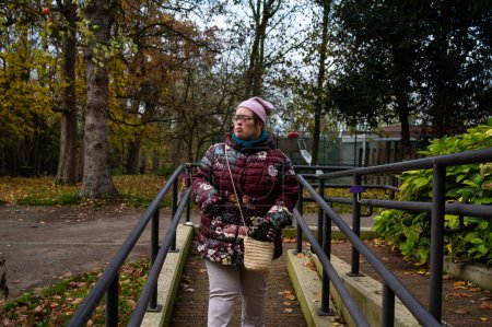 Foto de 40 años mujer blanca con síndrome de Down, vistiendo paños de invierno caminando por la isla al aire libre, Flandes, Tienen, Bélgica - Imagen libre de derechos