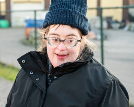 Foto de 40 year old happy white woman with the Down Syndrome, wearing a hat and a winter jacket, Tienen, Flanders, Belgium - Imagen libre de derechos