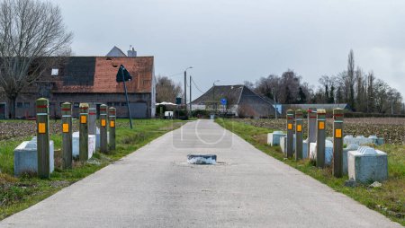 Téléchargez les photos : Merchtem, Région flamande du Brabant, Belgique, 25 février 2023 - Déclenchement de la vitesse du tracteur au milieu d'une route de campagne - en image libre de droit