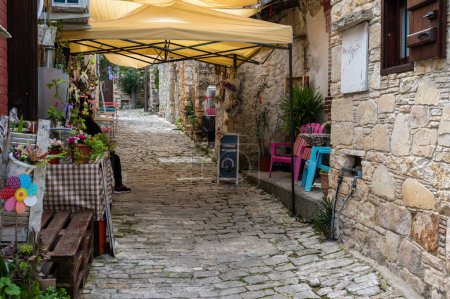 Foto de Lofou, Limassol District, Chipre, 24 de marzo de 2023 - Callejón estrecho tradicional en el pueblo con tiendas y terrazas de restaurantes - Imagen libre de derechos