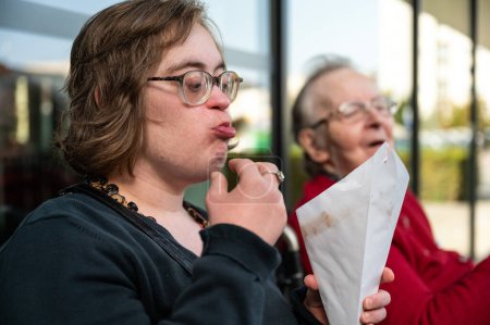 Téléchargez les photos : Femme trisomique mangeant des frites avec sa mère de 85 ans, Tienen, Flandre, Belgique - en image libre de droit