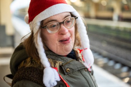 Téléchargez les photos : Joyeux 41 ans avec le syndrome de Down portant un chapeau de Noël à la gare, Bruxelles, Belgique - en image libre de droit