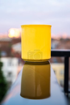Yellow mug reflecting in a wet black sruface, Brussels, Belgium