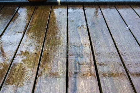 Nasse Oberfläche einer Terrasse mit Holzplanken und plätscherndem Regen, Brüssel, Belgien
