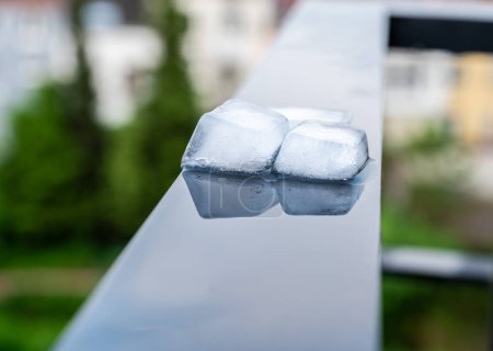 Cubos de hielo reflejados en una superficie negra y húmeda, Bruselas, Bélgica