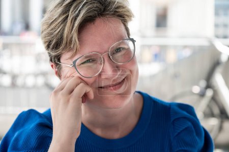 Portrait of an 38 yo white woman wearing glasses and a blue shirt, Brussels, Belgium. Model released.