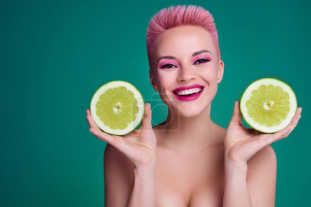 Téléchargez les photos : Closeup portrait of young bright appearance stunning pink make up woman hold two citrus slices exfoliation healthcare. - en image libre de droit