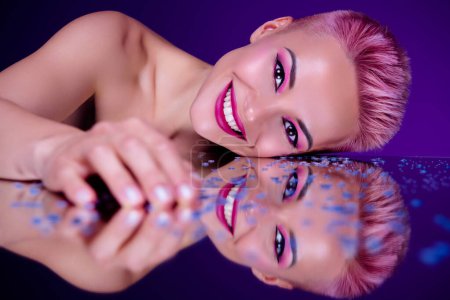 Téléchargez les photos : Futuristic vivid portrait of young woman model lying naked on glossy mirror covered sparkling drops cosmetics promo. - en image libre de droit