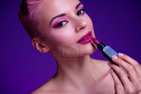 Photo for Closeup photo of fashionista girl apply matte glossy resolution lipstick on plump lips smooth decorative trendy color. - Royalty Free Image