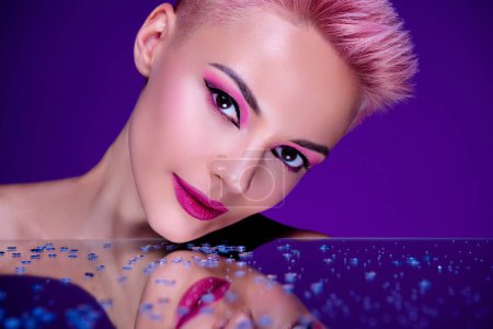Téléchargez les photos : Teasing fantaisie yeux magnétiques regarder femme publicité nouveaux cosmétiques visage collection violet magenta couleurs baclground. - en image libre de droit