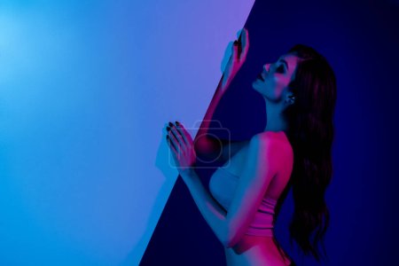 Photo for Side portrait of stunning girlfriend at disco party modern event hold blue neon wall advertising inviting clients club. - Royalty Free Image