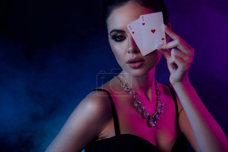 Photo for Photo of stunning chic lady risky playing poker in mist club bet huge amount money on dark ultraviolet background. - Royalty Free Image