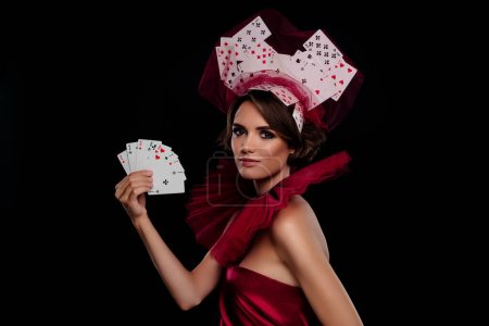 Photo for Amazing beautiful woman poker dealer hold fan of cards wear masquerade costume casino vip night time. - Royalty Free Image