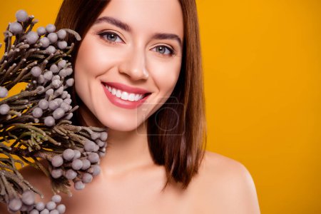 Photo for Closeup studio photo face young woman touch her cheek exotic bunch dry flowers enjoy fluffy bloom yellow background. - Royalty Free Image