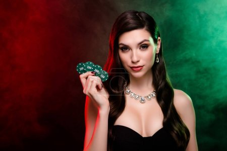 Foto de Mujer experimentada distribuidor celebrar juego de póquer cien fichas apuestas poker club póquer noche cigarrillo humo. - Imagen libre de derechos