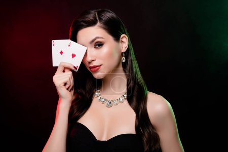 Photo for Studio photo stunning woman dealer hold card vip private party poker club poker night neon filters reflect on long hair. - Royalty Free Image