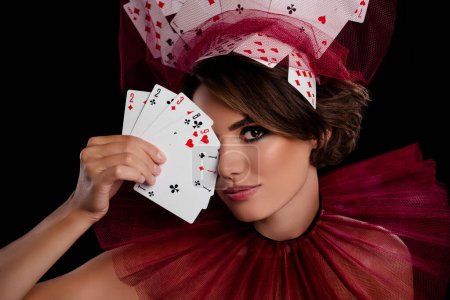 Photo for Studio photo stunning woman dealer hold cards near face close eye wear masquerade costume casino night game. - Royalty Free Image