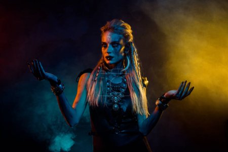 Foto de Retrato de misteriosa chica vikinga encantadora negro magia ritual luces coloridas niebla aislada sobre fondo negro. - Imagen libre de derechos