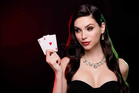 Photo for Stunning female dealer hold poker game two ace cards betting gambling poker club poker night lighted by neon filters. - Royalty Free Image