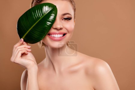 Photo for Photo of pretty sweet lady nude shoulders ficus leaf cover close eye empty space isolated brown color background. - Royalty Free Image