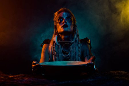 Téléchargez les photos : Photo de légende du nord sorcier fille interagir morts préparer potion de bataille orange lumières bleues isolées sur fond sombre. - en image libre de droit