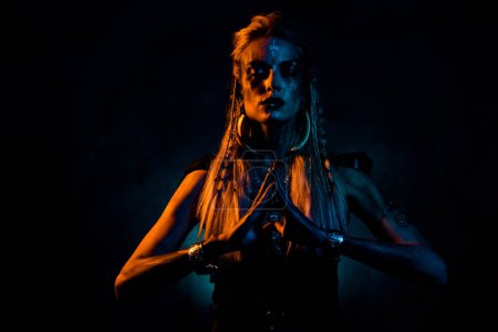 Foto de Foto de señora peligrosa salvaje usar ropa vikinga rezando dioses de la muerte aislado naranja oscuro color azul fondo. - Imagen libre de derechos