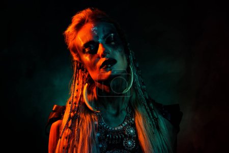 Foto de Foto de la señora misteriosa sexy miedo usar ropa vikinga ojos cerrados rezar demonios aislados color naranja oscuro fondo. - Imagen libre de derechos