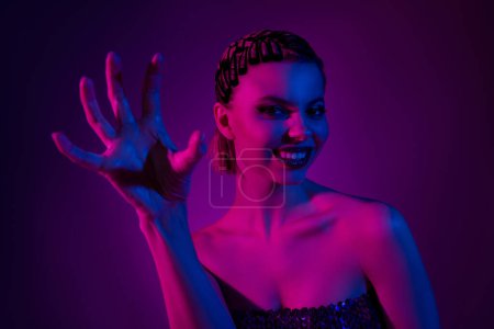 Photo for Photo of stunning gorgeous lady make scratch gesture playing devil in night club event over neon background. - Royalty Free Image